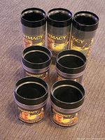 Top view of 7 pharmacy themed cups arranged together on a table, showing colorful pharmacy graphics and black rims.