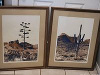Image showing two framed desert landscape prints side by side. Each print measures 30x24 inches. The left print shows a tall agave plant with mountains in the background; the right print shows a saguaro cactus with desert mountains.