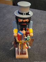 Full front photo of the nutcracker showing hat, glasses, beard, and colorful painted coat.