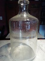 Full view of the clear glass carboy with Pyrex embossing visible, showing overall shape, size, and condition.