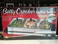 Photo of Betty Crocker branded box showing Buffet Server with three compartments filled with food and details of features including adjustable temperature and see-through lids.