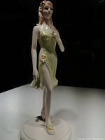 Full view of the Coalport figurine showing pale green dress with flower details and pose, approximately 7.5 inches tall.