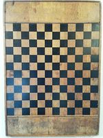 Top-down view showing the checkered playing surface and natural wood border with some wear and aging marks.