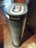 Front view of the Honeywell tower air purifier showing the brand name and ribbed black cylindrical body.