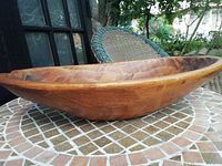 Side profile photo showing elongated oval shape and wood grain pattern of the bowl.