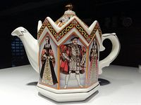 Hexagonal Sadler teapot with painted panels showing King Henry VIII with three of his wives, set against colorful geometric and floral details.