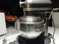 Side view of assembled mixer with bowl and splatter guard on countertop