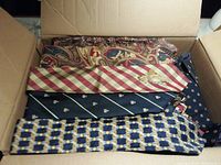 Box open showing ties in various colors and patterns including paisley, stripes and geometric designs.