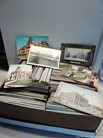 Box containing hundreds of postcards with several sample cards displayed upright on top