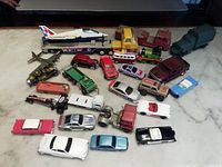 Full overview of the entire lot showing all toy vehicles including toy airplane on trailer, toy train engine, helicopters, and various toy cars and trucks.