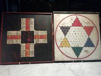 Side by side view of the Parcheesi and Chinese Checkers wooden game boards placed upright, showing full layout and colors.