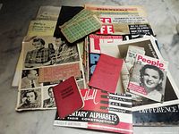 Overview photo of the collection showing vintage magazines, booklets, postcards, and various paper ephemera spread out in a pile.