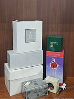 Stack of vintage Christmas ornament boxes including Appalachian Spring, Department 56, and white/silver unbranded boxes.