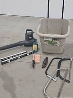 Photo showing the outdoor garden caddy, leaf blower, three saws (bow saw, pruning saw, hand saw), garden shears and metal level tool.