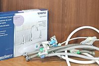 AquaSource Northridge bathroom faucet set in box with assorted faucet hoses.