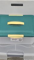 Close-up image of 40 quart Sterilite container with teal lid and yellow latches