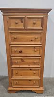 Front view of the tall pine dresser showing all 5 drawers closed.