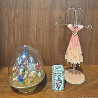 Photo showing all three items together: the jewelry holder, the nativity dome, and the holiday tin.