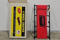 Red padded 6 wheel mechanic creeper with a soft headrest and black metal frame.