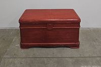 Front view of the closed vintage cedar hope chest with reddish finish and simple base design.