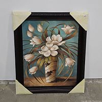 Full view of framed Vision in White floral art print with white flowers in a vase on blue background. Corners protected with paper guards.