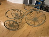 Side angle showing the bicycle shape and the large circular holders for potted plants.