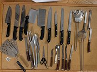 Full layout of lot showing knives, cleavers, scissors, forks, spoons, spatulas and peelers