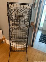 Front view showing three swinging wire baskets with decorative loop design on each basket's sides, stacked vertically.