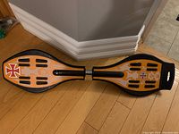 Top view of Ripstik caster board showing orange deck with grip tape and decorative flames and crosses.