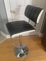 Black and white padded kitchen/bar stool chair with chrome base and height adjustment lever.