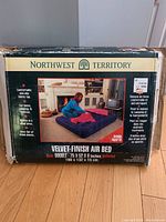 Box front showing product name, image of air bed with a woman arranging bedding, size details and product features.