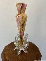 Full height view of vase showing elegant curves and swirling pink and green pattern with clear footed leaf base.