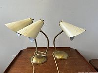Pair of vintage Mid-Century Modern gooseneck adjustable spotlight table lamps on wooden surface.