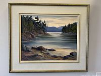 Full view of the painting showing the landscape scene framed and matted.