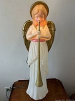 Full view of the angel figure with visible power cord.