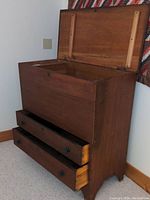 Front angle of the antique wooden blanket chest showing the top lid open and two bottom drawers pulled out.