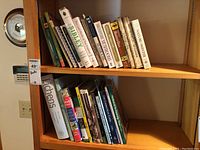 Books on shelves showing a variety of books including plant, nature and map themes, all in good condition
