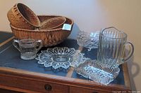 Overview photo showing all glassware items and woven basket set on a wooden table.