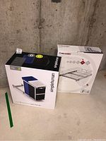 Photo of Simplehuman dual compartment pull-out can and Rev-A-Shelf organizer boxes against concrete wall