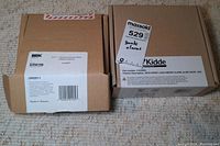 Two boxed smoke alarms showing first alert BRK and Kidde brands, identifying lot items.