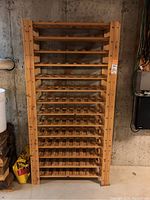 Front view of the tall wood wine rack showing multiple horizontal slats for wine bottle storage.
