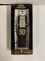 Front view of the coin bank inside original retail box showing Gas+ logo, Regular fuel sign, and 50 Years emblem