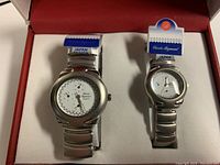 Pair of Charles Raymond his and hers wristwatches in box with tags, showing faces and bands.