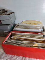 Boxes and folders filled with various stamps and envelopes for storage and organization