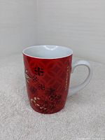 Front view of Starbucks coffee mug showing red color and flower design with Starbucks logo