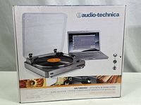 Box showing the Audio-Technica USB turntable with laptop displaying recording software on screen.