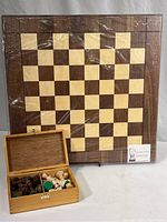 Full view of chess board wrapped in plastic with wooden box of pieces in front