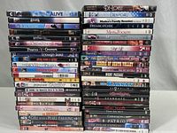 Photo shows stacks of 49 DVD titles including Staying Alive, Chicago, Harry Potter and the Order of the Phoenix, The Lord of the Rings, Pirates of the Caribbean, and others.