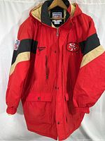 Full front view of red SF 49ers jacket with hood, zipper, and snap buttons.
