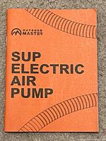 Close-up photo of the manual cover showing 'Outdoor Master SUP Electric Air Pump' text in orange and black.